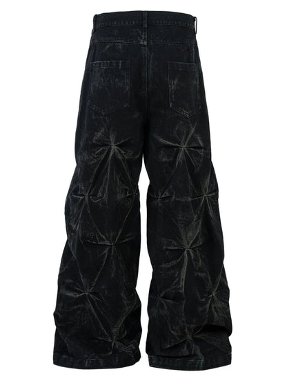 Rear view of black men's wide-leg jeans with two back pockets and gathered seams down both legs.
