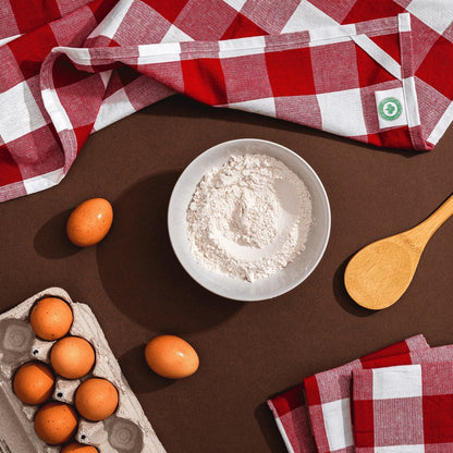 Red-and-white plaid kitchen towels arranged beside baking ingredients and utensils; props not included.