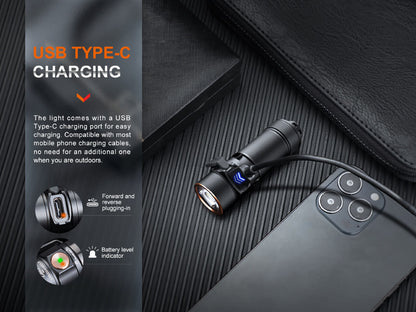 Fenix E18R V2 connected to a USB-C charging cable beside a phone