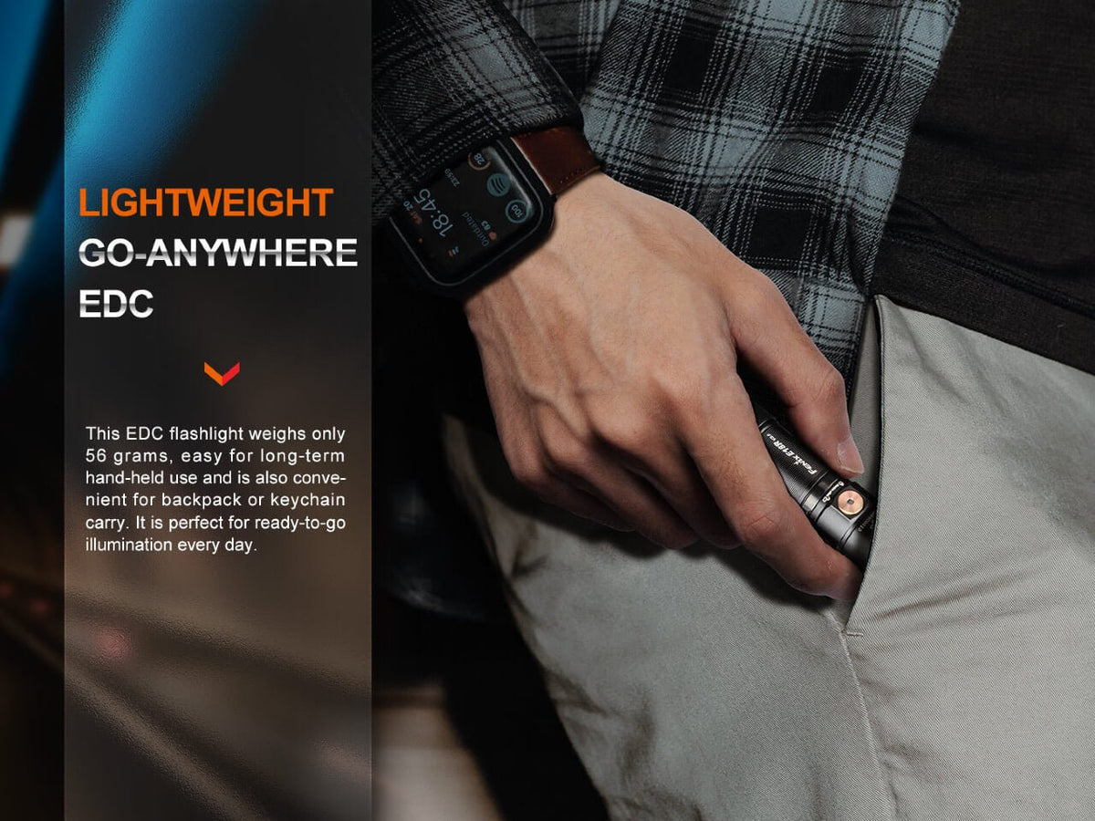Compact Fenix E18R V2 flashlight held beside a trouser pocket