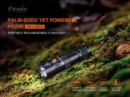 Fenix PD25R rechargeable flashlight resting on moss-covered wood.