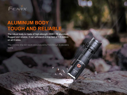 Black Fenix PD25R resting on a rock, showing its textured cylindrical body and pocket clip.
