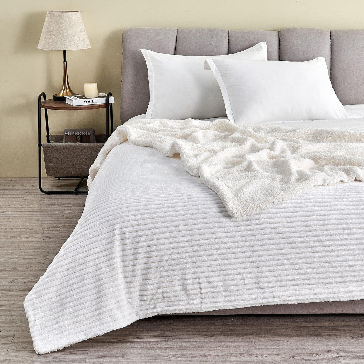 White ribbed sherpa blanket spread across a bed with its pale reverse folded back; pillows and furnishings are not included.