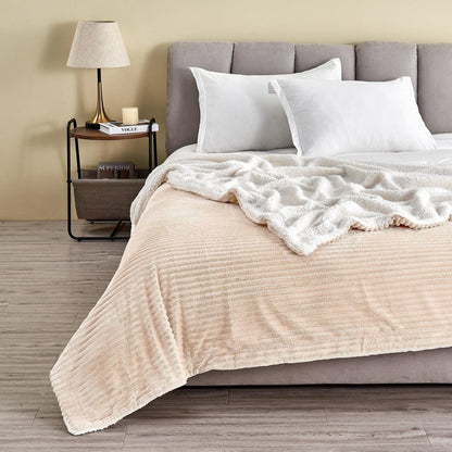 Cappuccino ribbed sherpa blanket spread across a bed with its pale reverse folded back; pillows and furnishings are not included.