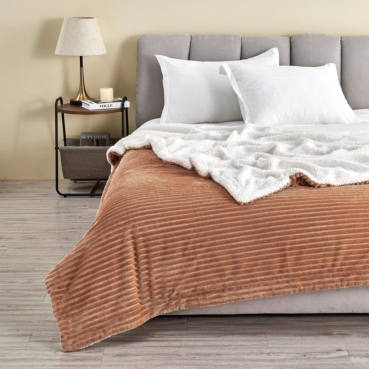 Toffee ribbed sherpa blanket spread across a bed with its pale reverse folded back; pillows and furnishings are not included.