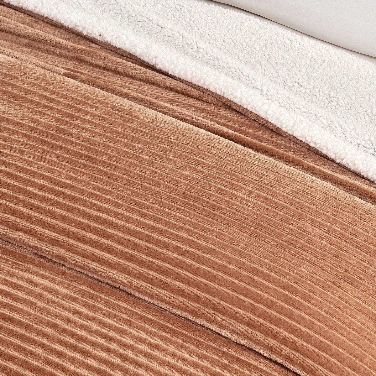 Close-up of the toffee ribbed face and pale sherpa reverse of the blanket.
