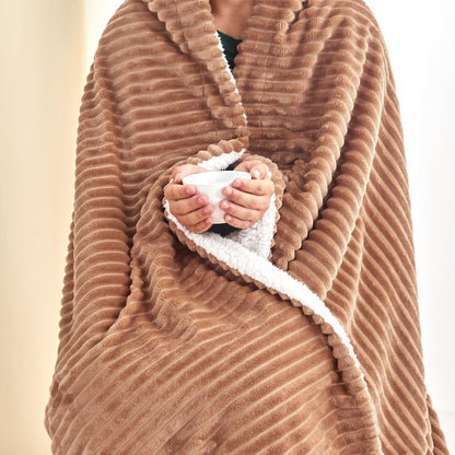 Person wrapped in the toffee ribbed sherpa blanket while holding a mug; one blanket only.