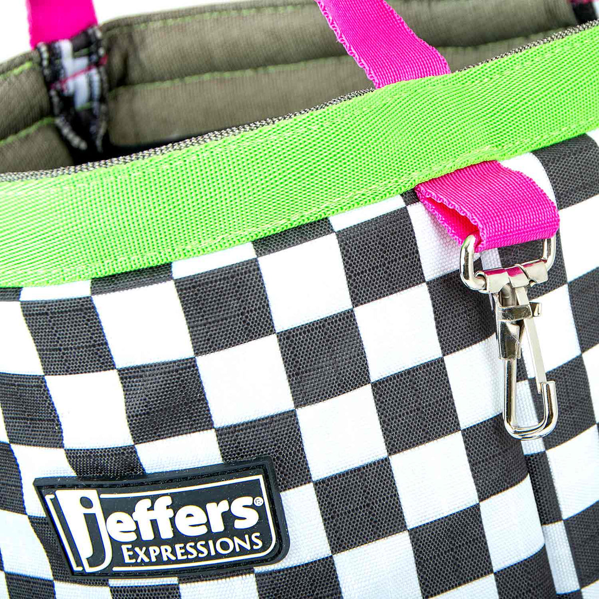 Close-up of the Skater Cowgirl tote's checkerboard print, neon-green trim, Jeffers patch, and hot-pink clip strap.