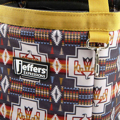 Close-up of the Thunderbird tote's geometric horse pattern, golden-yellow trim, Jeffers patch, and metal clip.