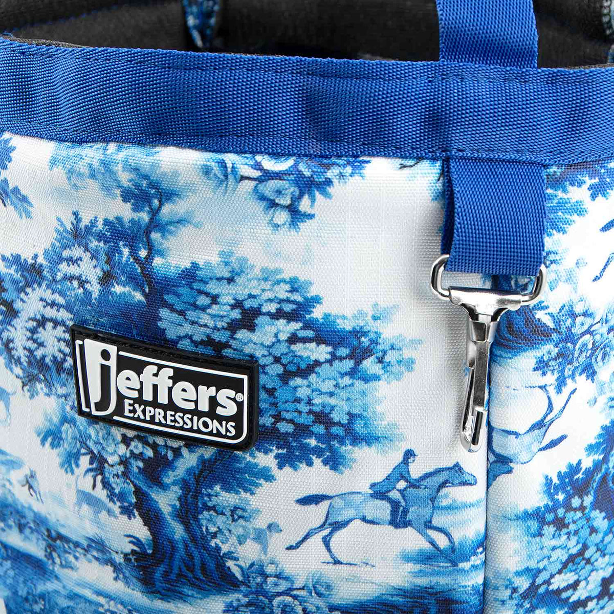 Close-up of the Equestrian Toile tote's blue-and-white horse print, blue trim, Jeffers patch, and metal clip.