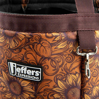 Close-up of the Bloomin' Toolin' tote's orange-brown floral print, brown trim, Jeffers patch, and metal clip.