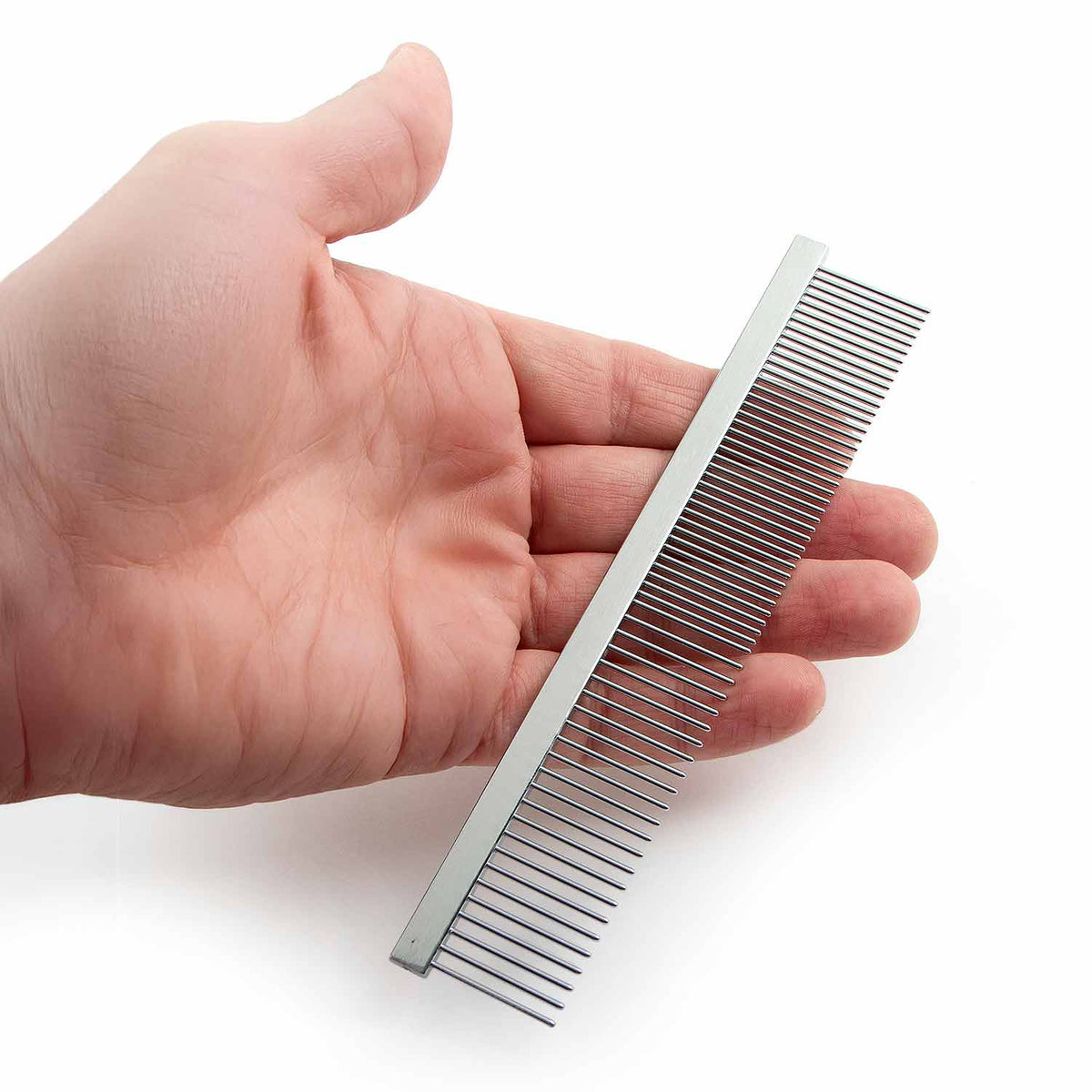 A hand holding one flat-back steel grooming comb.