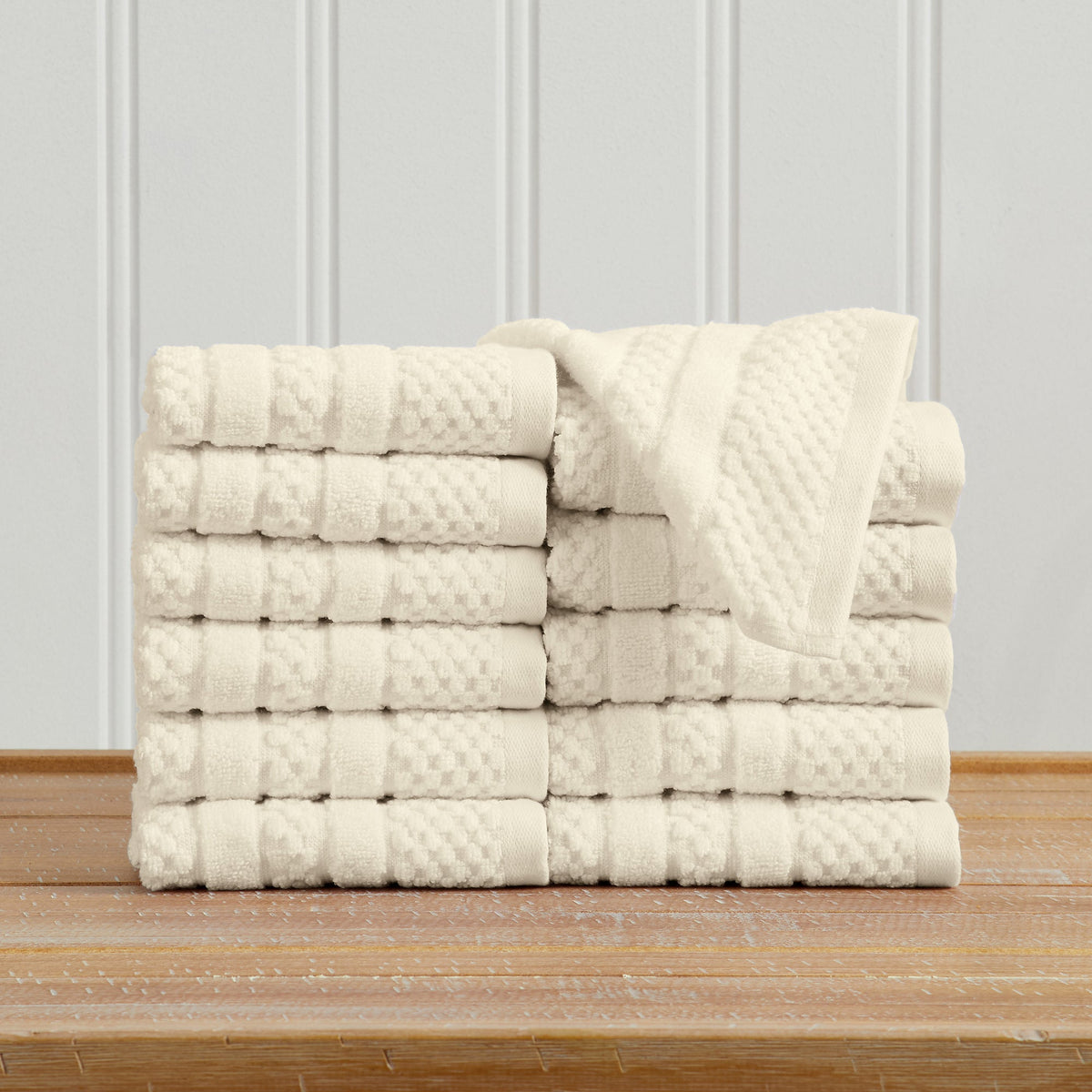 Ivory Giuliana Collection checkered jacquard washcloths folded and stacked.