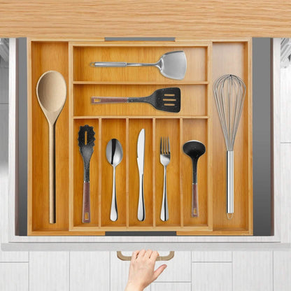 Top view of the bamboo organizer in an open drawer; utensils, hand, drawer and cabinetry are not included.