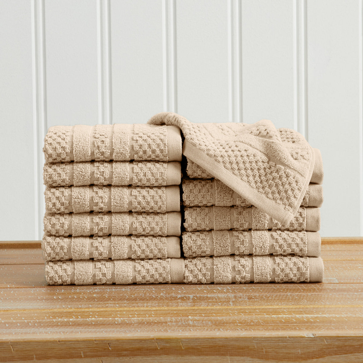 Sandstone Giuliana Collection checkered jacquard washcloths folded and stacked.