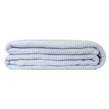 Light blue cotton waffle weave throw folded on a white background