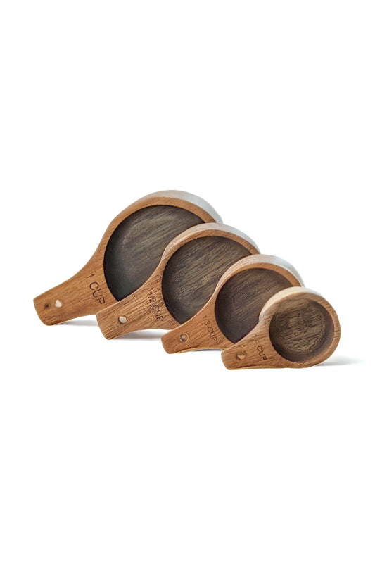 Four wooden measuring cups arranged from largest to smallest on a white background