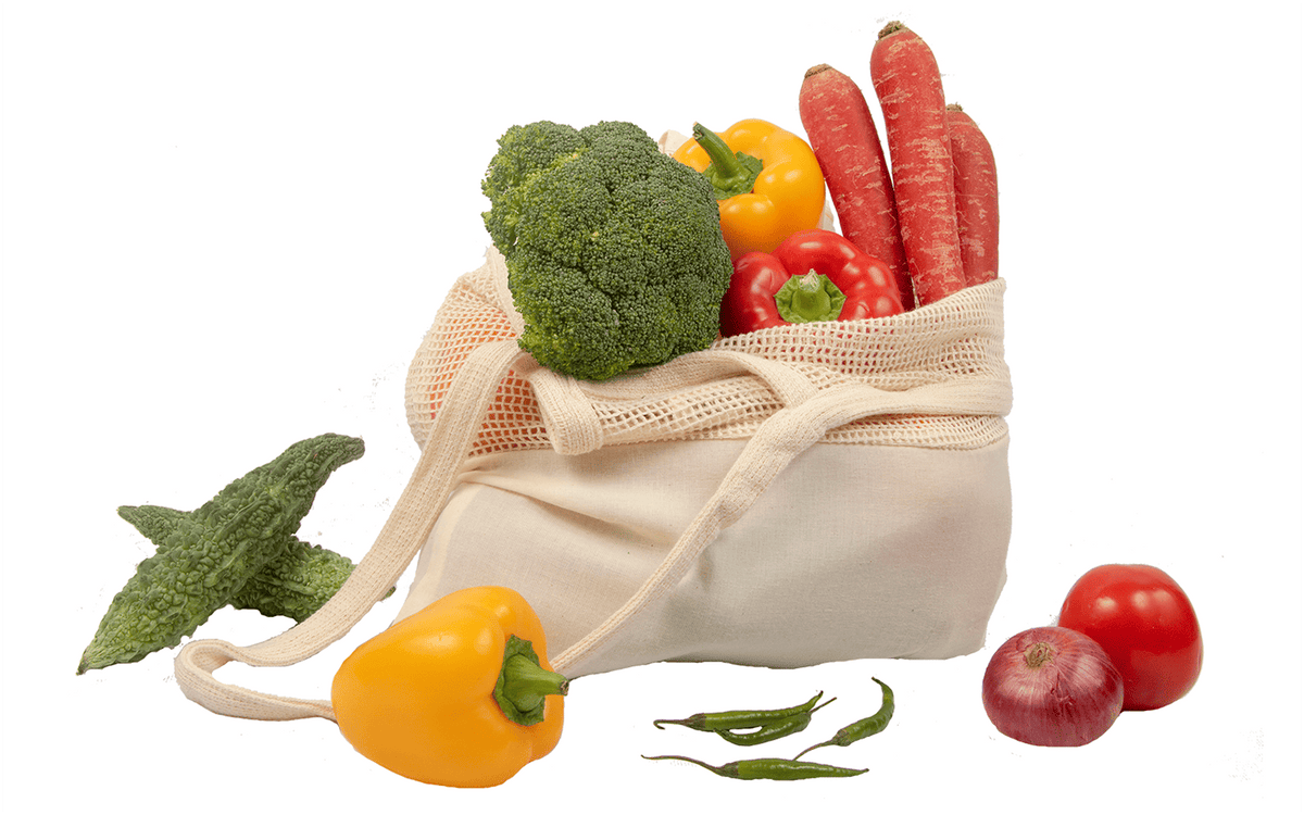 Close-up of the cotton mesh tote holding vegetables, showing its mesh upper section and fabric lower panel; produce is not included.