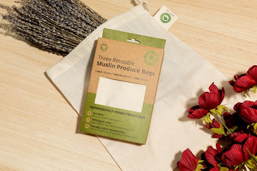 Muslin produce-bag gift box with cream fabric bags on a wooden surface; decorative flowers are not included.