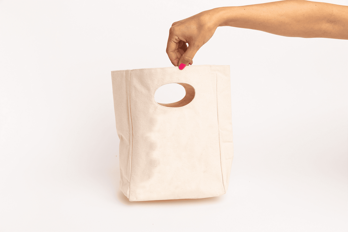 Plain panel view of the canvas lunch bag held by its handle