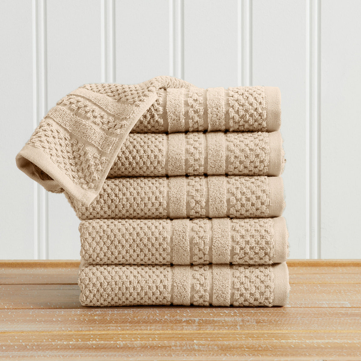 Sandstone Giuliana Collection checkered jacquard hand towels folded and stacked.