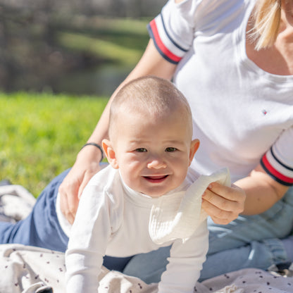 Parent holding a baby outdoors and holding a reusable cotton wipe