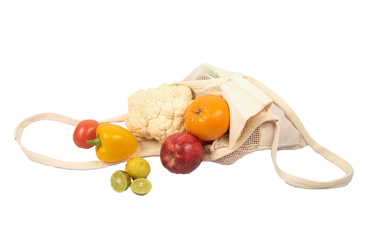 Cotton mesh tote laid on its side with fruit and vegetables; display food is not included.