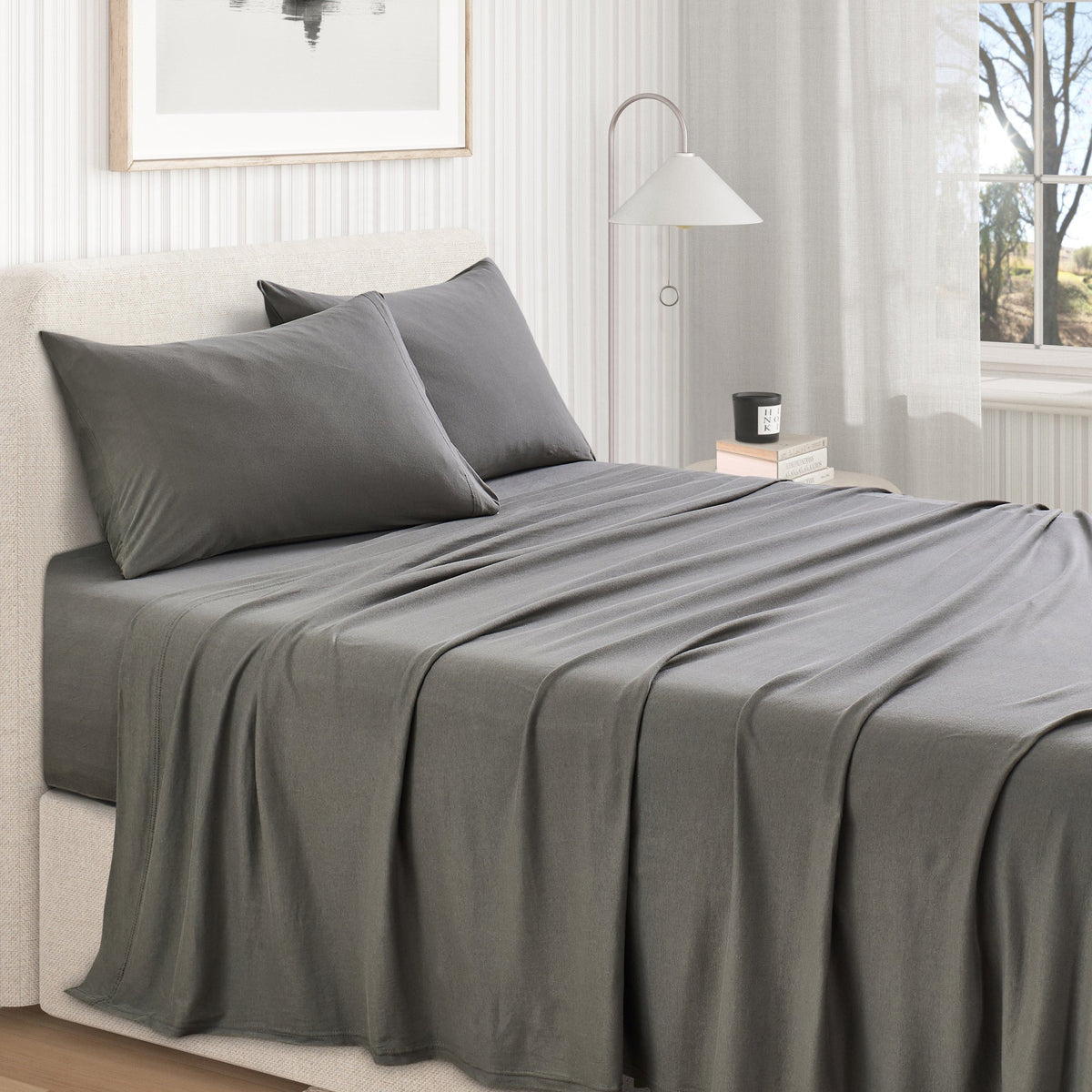 Olive Green cotton jersey knit sheet set shown on a made bed from a second room angle, with matching pillows and draped sheet.