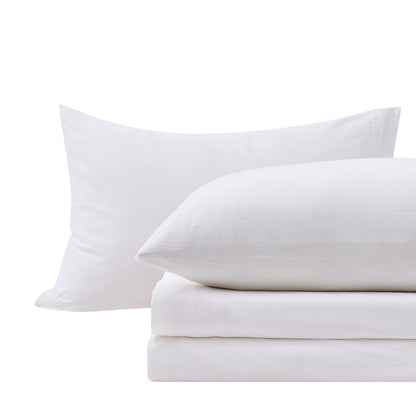 Close-up of White cotton jersey-knit pillowcases and matching sheet fabric.