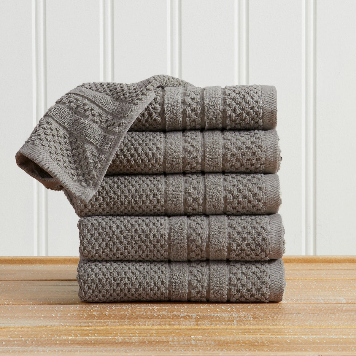 Dark Grey Giuliana Collection checkered jacquard hand towels folded and stacked.