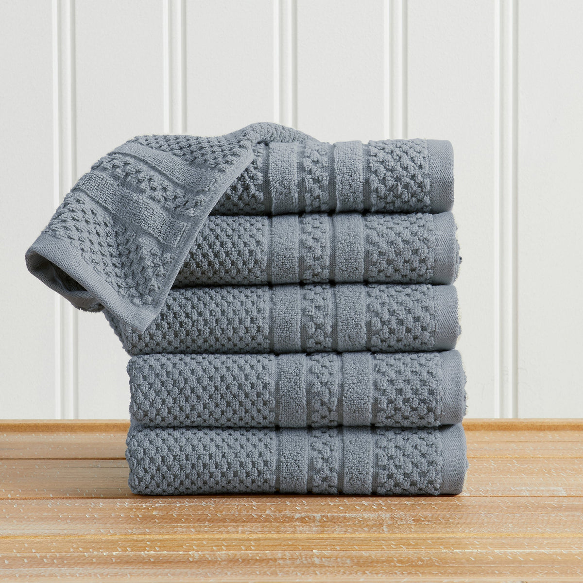 Blue Giuliana Collection checkered jacquard hand towels folded and stacked.