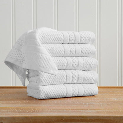 White Giuliana Collection checkered jacquard hand towels folded and stacked.